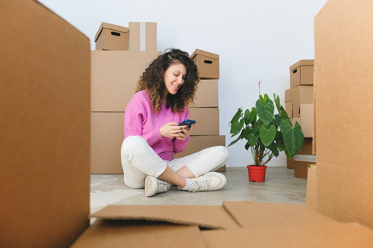 woman sitting on floor looking at sms